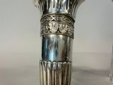 a silver vase that is sitting on a table