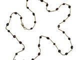 une image représentant une longue chaîne composée de perles noires sur fond blanc
