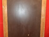 a blackboard on the floor in front of a red wall
