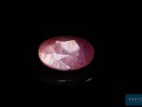 a close up of a pink stone on a black surface