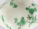underside view of a green and pink plate with flowers and vines