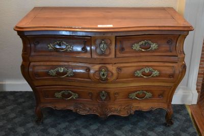a wooden chest of drawers with brass hardware on it