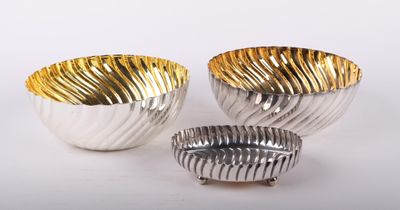 trois bols en argent et en or sur fond blanc