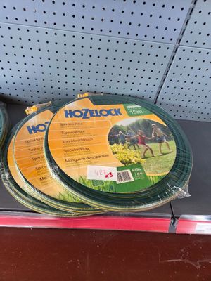 three green hoses sitting on a shelf in a store