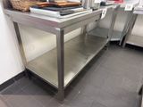 a stainless steel work table with a basket on top of it