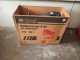 a cardboard box with a compressor in it sitting on the floor
