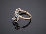a gold and diamond ring on a reflective surface