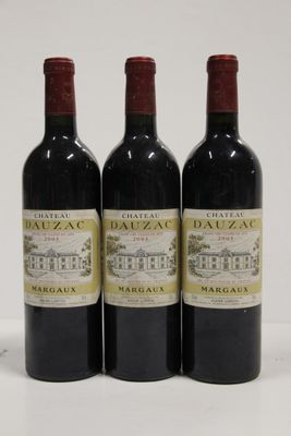 three bottles of red wine are lined up on a white surface