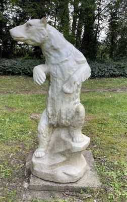 une statue d'ours qui se dresse dans l'herbe