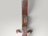 an old wooden sword with a carved handle on a gray background