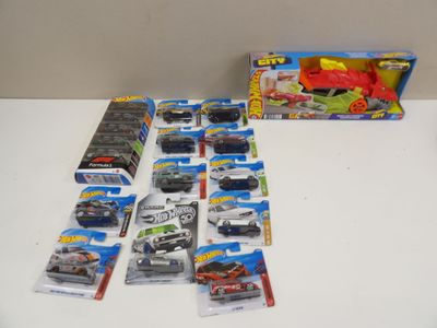 il y a plein de petites voitures Hot Wheels sur la table