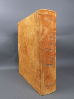 an old book sitting on top of a table with a gray background