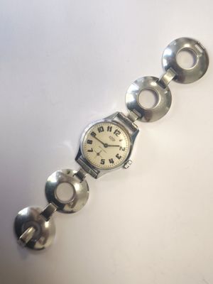 une photo d'une montre-bracelet argentée posée sur une surface blanche