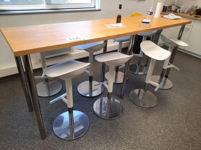 plusieurs tabourets et une table dans une pièce dotée d'une fenêtre