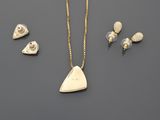 a close up of a necklace, earrings and ring on a table