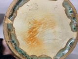 a person holding a plate with a yellow and green design on it