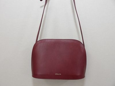 a red purse hanging on a wall with a white background