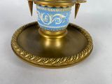 a blue and gold vase on a gold plate on a white background