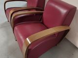three red leather chairs sitting next to each other in a warehouse