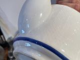 a person pouring water into a white tea pot