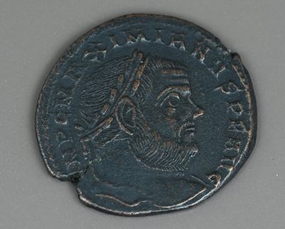 Gros plan sur une pièce de monnaie représentant un homme.