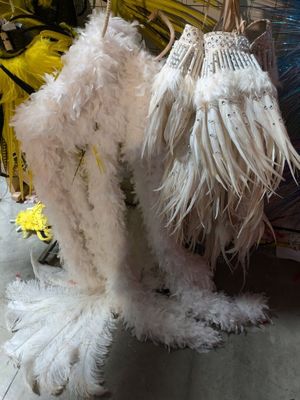 two umbrellas with feathers hanging from them on a rack