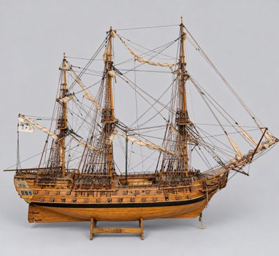 an old wooden model of a tall ship on a stand