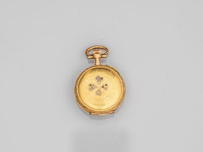 a close up of a gold pocket watch on a white surface