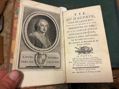 quelqu'un tient un livre sur lequel figure la photo d'un homme en costume