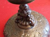 a bronze plate with a statue on it on a red table