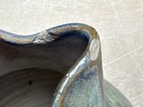 a close up of a blue vase on a table
