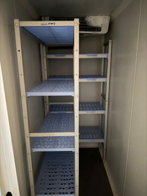 a small room with a shelf and shelves in it