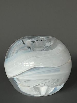 un vase en verre blanc et bleu posé sur une table