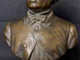 bronze bust of a man with curly hair on a marble base