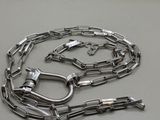 a silver chain with a clasp on it on a white surface