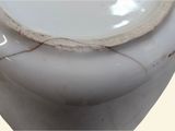 a close up of a white toilet with a cracked seat