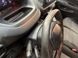 a steering wheel and dashboard of a car with a clock on it