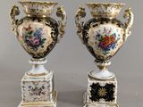 paire de vases anciens ornés de motifs floraux sur un fond gris
