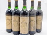 six bouteilles de vin sont alignées sur une surface blanche