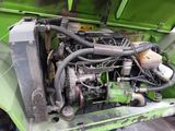 a green truck with a big engine in the back