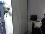 a room with a desk, chair, and a plant in it