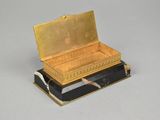a gold box with a knife in it on a table