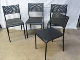 quatre chaises en métal noir disposées devant un fond blanc