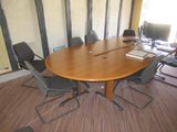 une photo d'une table de réunion entourée de chaises