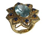 une image représentant une bague en or sertie d'une pierre bleue entourée de saphirs bleus