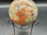 une image représentant une boule de verre colorée posée sur un socle