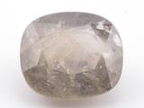 un gros plan d'un diamant brut blanc sur une surface blanche