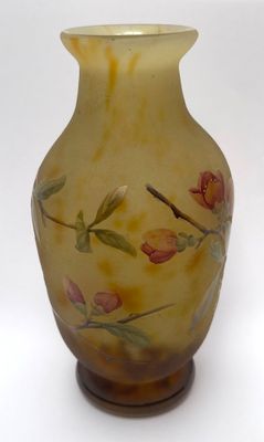 a yellow vase with flowers painted on it on a white background