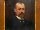 portrait d'un homme moustachu, vêtu d'un costume noir et d'une chemise blanche