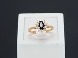 un gros plan d'une bague en or sertie d'un diamant noir et blanc